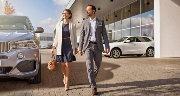 Die Deutsche Leasing als kompetenter und zuverlässiger Partner für Mobilitätslösungen Wir sind Mobility - zwei Personen (Frank Hägele und Dr. Hubertus Mersmann) stehen vor verschiedenen Autos und stellen sich vor